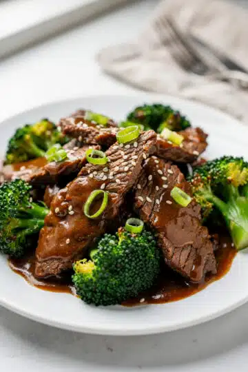 Crockpot Beef and Broccoli 9 Crockpot beef and broccoli with glossy sauce over rice in ceramic bowl.