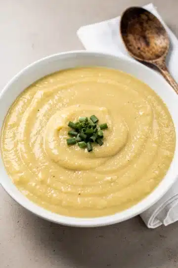 Creamy Potato Leek Soup 11 Creamy potato leek soup in a white bowl garnished with fresh chives.