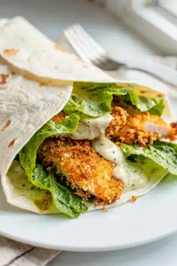 Crispy Chicken Caesar Wrap 13 Crispy chicken Caesar wrap with golden strips and creamy glossy dressing.