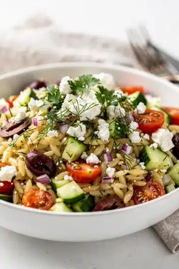 Lemon Orzo Spring Salad 12 Lemon orzo spring salad with feta, tomatoes, and fresh herbs in bowl.