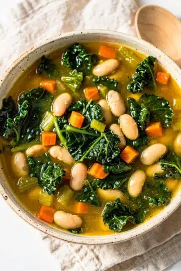 White Bean Kale Soup 12 Creamy white bean kale soup recipe in a rustic ceramic bowl.