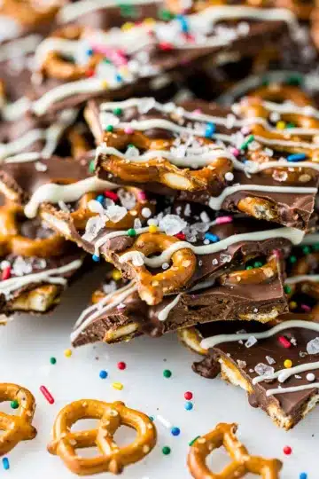 Chocolate Covered Pretzel Bark 11 Chocolate covered pretzel bark with sprinkles and salt on rustic board