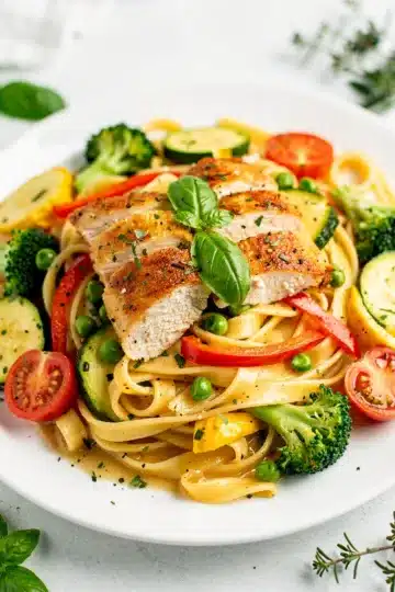 Chicken Primavera Pasta 11 Creamy chicken primavera pasta with colorful vegetables and glossy fettuccine noodles.