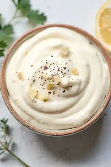 Garlic Aioli 14 Creamy garlic aioli in a bowl with minced garlic, lemon, and fresh thyme.