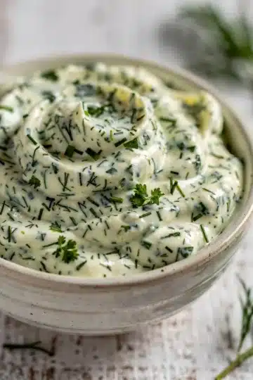 Herb Mayonnaise 12 Creamy homemade herb mayonnaise with fresh dill and parsley in a bowl.