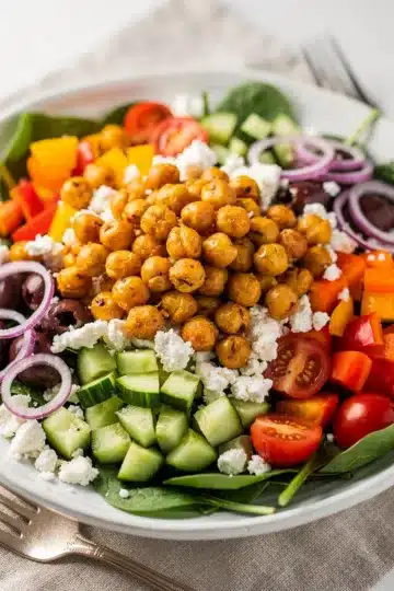 Crispy Chickpea Greek Salad 11 Crispy chickpea Greek salad with feta, tomatoes, cucumbers, olives, and spinach.