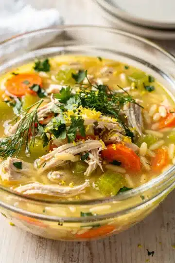 Lemon Chicken Orzo Soup 13 Creamy lemon chicken orzo soup in a white bowl with fresh dill garnish.