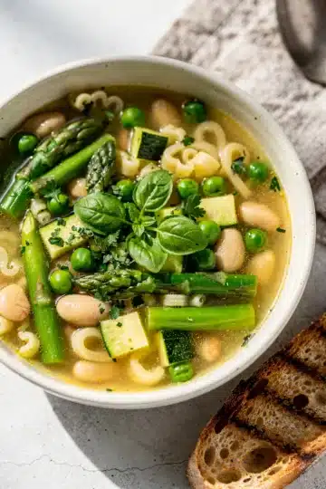 Spring Minestrone Soup 11 Rustic bowl of spring minestrone soup with asparagus, peas, and pasta.
