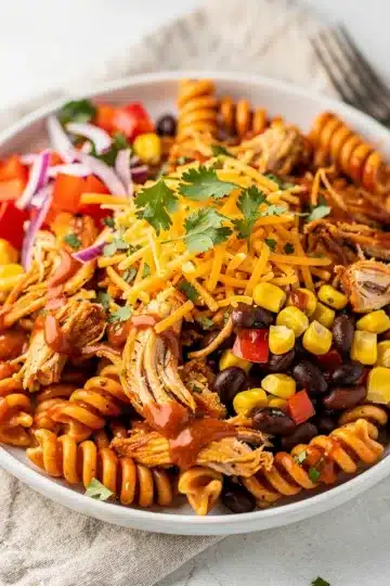 BBQ Chicken Pasta Salad 11 Creamy BBQ chicken pasta salad with corn, beans, and cheddar cheese.