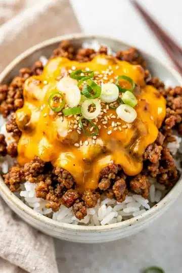 Cheesy Korean Ground Beef Bowl 13 Cheesy Korean ground beef bowl with gooey cheese over rice and green onions
