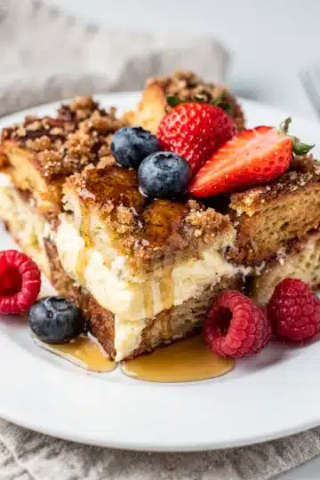 Classic Overnight French Toast Bake 11 Classic overnight French toast bake with berries and maple syrup on rustic table.