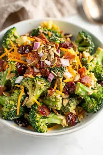 Creamy Broccoli Bacon Salad 13 Creamy broccoli bacon salad with cheddar and cranberries in a glossy dressing.