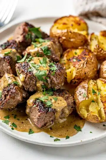Creamy Garlic Butter Steak Bites and Potatoes 11 Creamy garlic butter steak bites and potatoes in a rustic cast iron skillet.