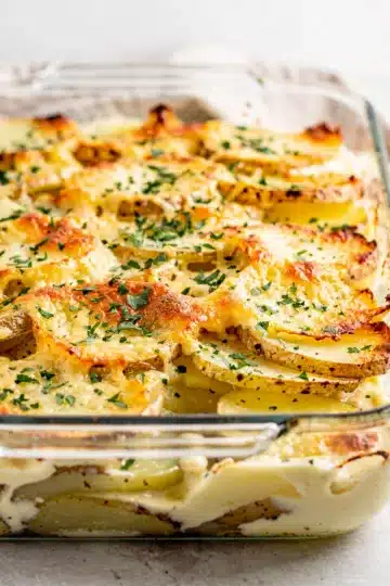 Creamy Garlic Parmesan Scalloped Potatoes 1 Creamy garlic parmesan scalloped potatoes with golden brown layers and melted cheese.