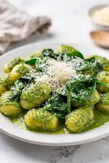 Creamy Pesto Gnocchi with Spinach 3 Creamy pesto gnocchi with spinach in a white ceramic bowl.