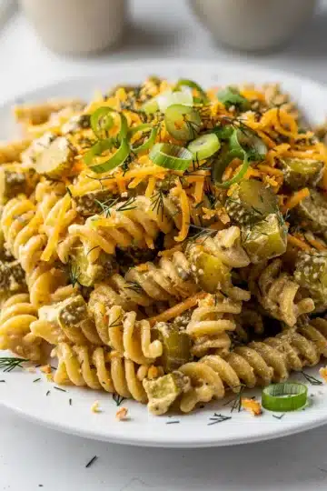 Easy Dill Pickle Pasta Salad 11 Creamy dill pickle pasta salad with rotini and cheddar cheese in a bowl.