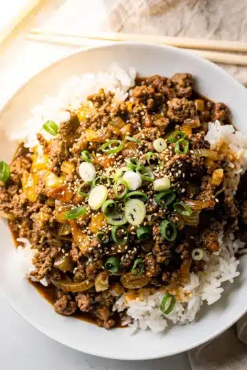 Easy Korean Ground Beef Bowl 11 Easy Korean ground beef bowl with glossy sauce over rice and green onions.
