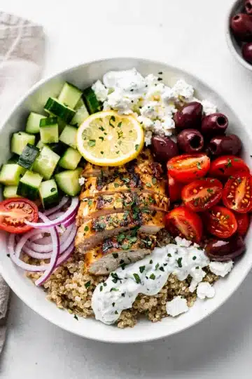 Mediterranean Chicken Bowl 13 Mediterranean chicken bowl with quinoa, fresh vegetables, feta, and tzatziki sauce.