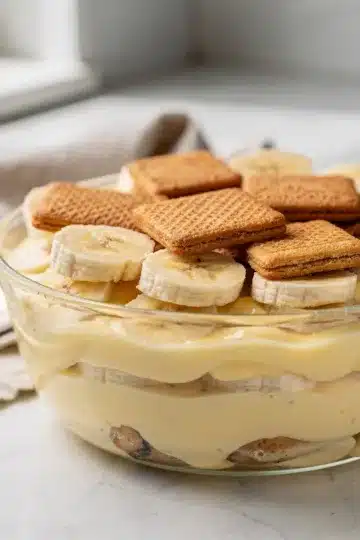 Old Fashioned Banana Pudding 11 Old fashioned banana pudding with creamy custard and vanilla wafers in a glass bowl.