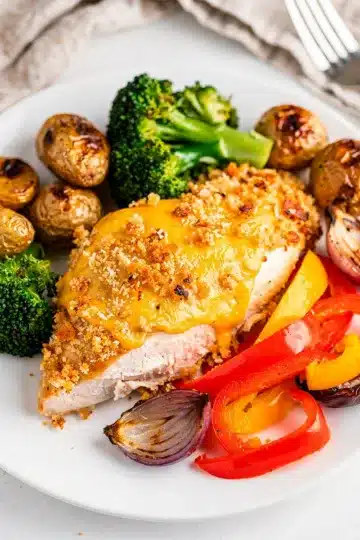 Skillet Parmesan Crusted Sheet Pan Chicken Dinner 11 Crispy parmesan crusted chicken with roasted potatoes and vegetables on sheet pan.