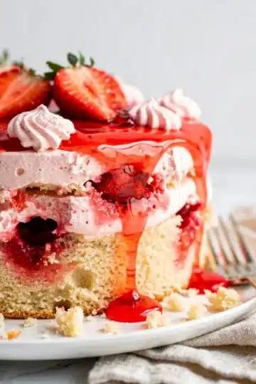 Creamy Strawberry Jello Poke Cake 13 Creamy strawberry jello poke cake slice with fresh strawberries and whipped cream
