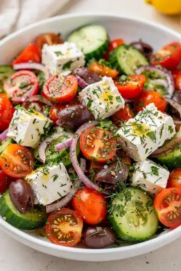 Tomato Cucumber Feta Salad 11 Vibrant tomato cucumber feta salad with olives and fresh dill in a bowl.