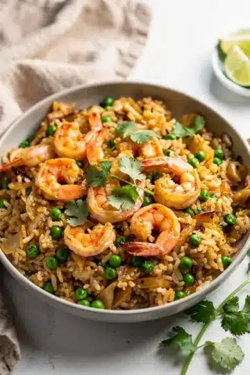 One Pan Coconut Lime Shrimp and Rice 2 Creamy coconut lime shrimp and rice with peas and fresh cilantro garnish.