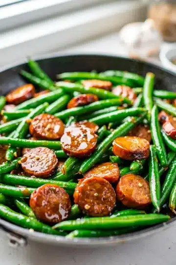 Honey Garlic Smoked Sausage and Green Bean Stir Fry 11 Glossy honey garlic sausage and green beans in cast iron.