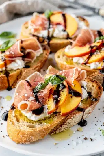 Peach Prosciutto Balsamic Bruschetta 11 Peach prosciutto bruschetta with mozzarella and balsamic glaze on toasted baguette