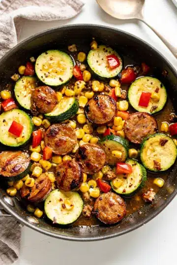 Kielbasa Zucchini and Corn Summer Skillet 1 Rustic skillet with summer sausage and vegetable medley in tomato sauce.