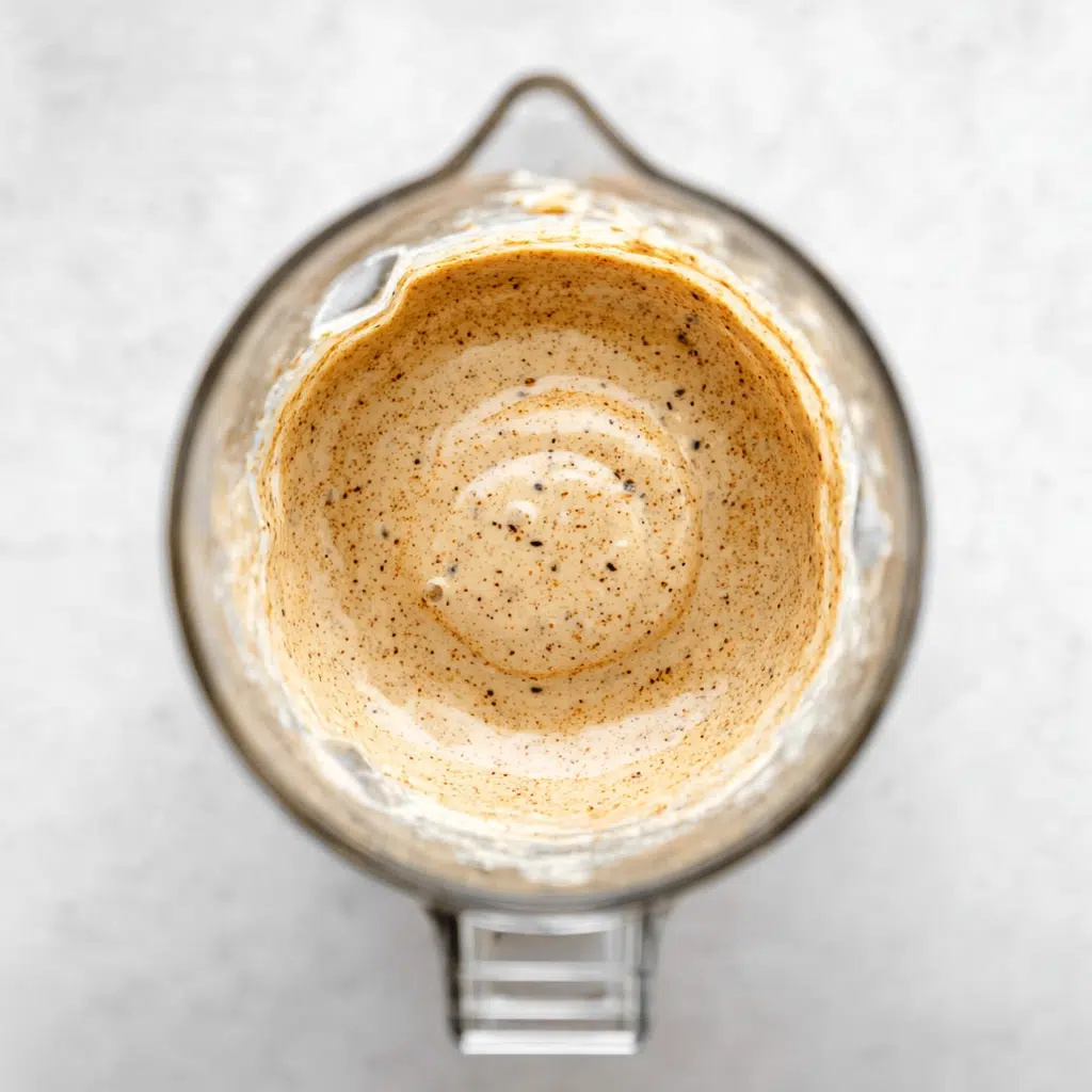 Blended Kodiak waffle batter in a glass blender with visible cinnamon and chia
