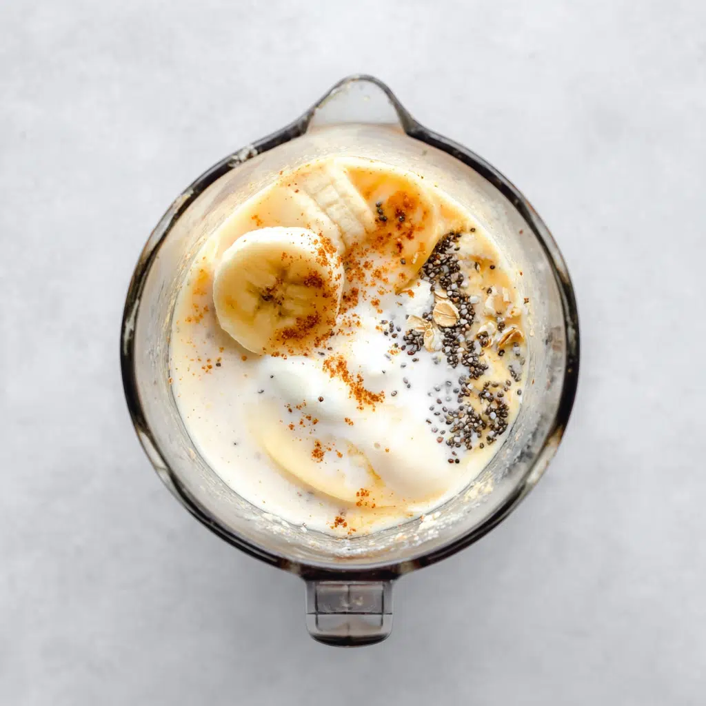 Blender filled with Kodiak waffle mix ingredients including banana, yogurt, milk, and chia seeds
