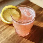 A glass of pink Himalayan salt weight loss drink with lemon