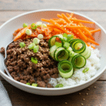 Korean beef bowl with rice, kimchi, and fresh vegetables.