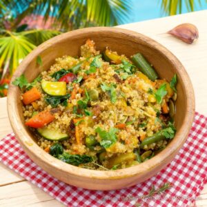 Colorful bowl of quinoa mixed with diced vegetables and herbs, fluffed and served warm.