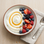 Healthy Greek yogurt bowl with fresh berries and honey drizzle.