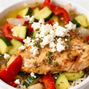 Mediterranean-style chicken with roasted vegetables, herbs, and crumbled feta, served in a vibrant bowl. slow Cooker Greek Chicken Bowls
