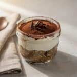 Tiramisu overnight oats in a jar with creamy layers and cocoa dusting