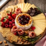 Valentine's Day snack board with baked brie, charcuterie, and fresh berries.