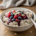 Creamy vanilla overnight oats in a jar with fresh berries and chia seeds.