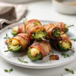 Close up of crispy bacon wrapped jalapeno poppers with creamy cheese filling