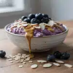 Creamy blended tofu and blueberry oats in a rustic ceramic breakfast bowl.