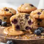 Healthy Greek yogurt blueberry protein muffins on a rustic wooden board.