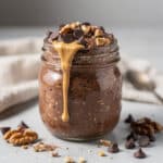 Creamy brownie batter overnight oats in a jar with chocolate chips.