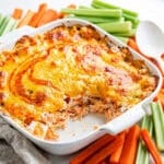 Creamy Buffalo chicken dip with melted cheese served with celery and chips