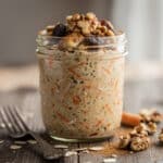 Creamy carrot cake protein overnight oats in a clear glass jar.
