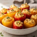Protein snack cheese stuffed mini peppers recipe on rustic wooden board.
