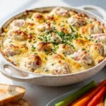 Creamy crab dip with cheese and chives served with crackers and bread