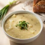 Creamy potato leek soup in a rustic bowl garnished with fresh green chives