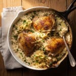 Creamy smothered chicken and rice dish with golden seared chicken thighs.